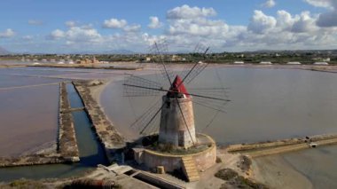 Avrupa 'da Sicilya, İtalya' da Marsala yakınlarındaki Tuz Küpeleri 'ndeki yel değirmenleri. Yazın Sicilya 'nın tuzlu krakerlerinde renkli yel değirmenleri