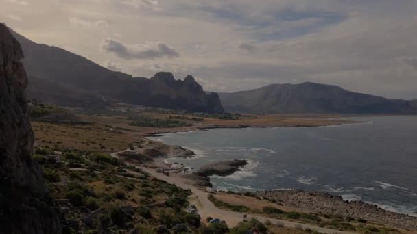 洞窟を飛行する無人機 サンヴィト カポイ シチリア サンヴィト ビーチ そして背景にあるモンテ モナコ シチリア北西部 シチリアの崖と岩の海岸線 — ストック動画