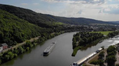 Almanya 'daki Mosel nehri üzerinden iç nakliye teknesi gaz nakliyesi nehirden geçen iç nakliye gemisi, Bernkastel' in üzüm bağları dağları. Moselle nehri gün batımında gaz tankeri