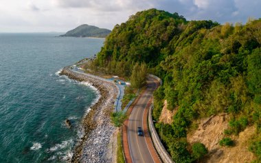 Tayland virajlı yolunda araba sürüyor. Yazın yol manzarası. Sahildeki otoyolda araba kullanmak çok güzel. Chantaburi Eyaleti Tayland, dağlarda kıvrımlı bir yolu olan mavi okyanus.
