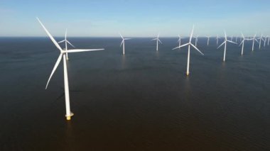Okyanustaki yel değirmeni parkı, elektrik üreten yel değirmeni türbinlerinin insansız hava görüntüsü Hollanda 'da denizde izole edilmiş yel değirmenleri. Denizdeki yel değirmeni türbinleri