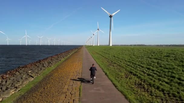 Joven Una Bicicleta Eléctrica Verde Una Granja Molinos Viento Los — Vídeo de stock