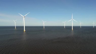 Okyanustaki yel değirmeni parkı, elektrik üreten yel değirmeni türbinlerinin insansız hava görüntüsü Hollanda 'da denizde izole edilmiş yel değirmenleri. Yel değirmenleri sırası