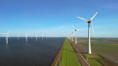 Okyanustaki yel değirmeni parkı, elektrik üreten yel değirmeni türbinlerinin insansız hava görüntüsü Hollanda 'da denizde izole edilmiş yel değirmenleri. Kıyıda ve kıyıda yel değirmeni parkı