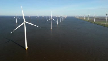 Okyanustaki yel değirmeni parkı, elektrik üreten yel değirmeni türbinlerinin insansız hava görüntüsü, Ijsselmeer Westermeerdijk Hollanda gölünde bir sıra yel değirmeni.