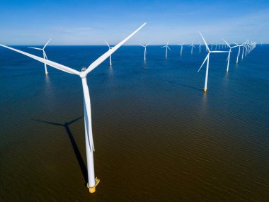 A group of wind turbines majestically spin in the ocean, harnessing the power of the wind to generate clean and sustainable energy. drone aerial view of windmill turbines green energy in the ocean clipart