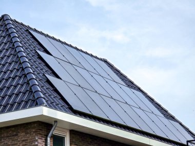 Çatıda siyah güneş panelleri olan yeni yapılmış evler, siyah güneş panelleri olan yeni modern evlerin kapatılması. Zonnepanelen, Zonne Energie, Çeviri: Güneş Paneli, Güneş Enerjisi
