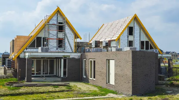 オランダの近代的な家屋を有する新しいオランダ郊外エリアの建設現場 新たにオランダに近代的な家族の家を建設 ストック画像