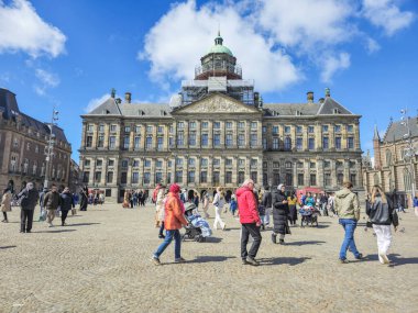 Amsterdam Hollanda 21 Nisan 2024 Dam Meydanı 'ndaki heybetli bir şehir binası önünde çeşitli bir grup insan birlikte yürüyor 