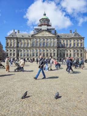 Amsterdam Hollanda 21 Nisan 2024. Muazzam, görkemli bir binanın önünde amaçsızca dolaşan bir grup insan. Baraj Meydanı Sarayı