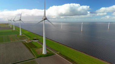 Baharda Hollanda 'daki yel değirmeni parkı, yel değirmeninin hava görüntüsü elektrik üreten türbinler, okyanusta ve karada yel değirmenleri.