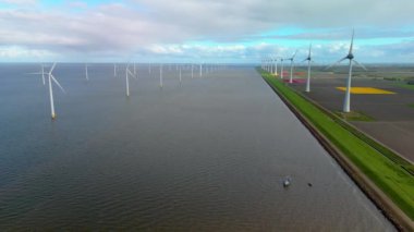 İlkbaharda Hollanda 'daki yel değirmeni parkı, rüzgar türbinlerinin insansız hava görüntüsü elektrik üreten yeşil enerji, Flevoland Noordoostpolder' deki Ijsselmeer gölündeki yel değirmeni çiftliği.