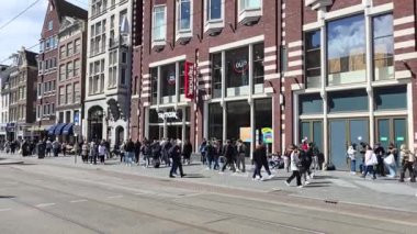 Amsterdam Hollanda 21 Nisan 2024, Damrak 'ta kalabalık bir şehir caddesinde yürüyen isimsiz bir kalabalık