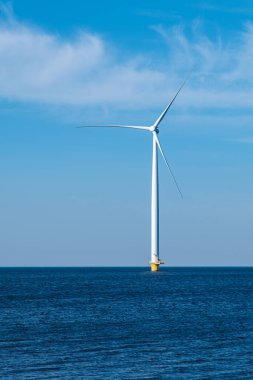 Uçsuz bucaksız okyanusta yalnız bir rüzgar türbini, sürdürülebilir bir gelecek için temiz enerji üretmek için rüzgarın gücünden faydalanıyor. Denizdeki yel değirmeni türbinleri, Avrupa 'daki yeşil enerji geçişi