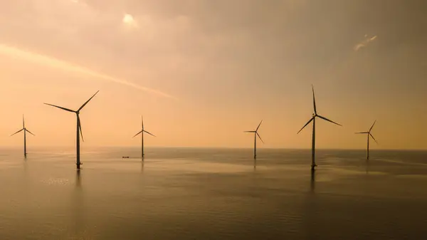 stock image A group of majestic wind turbines stand tall in the ocean off the coast of Flevoland, the Netherlands, harnessing the power of the wind to generate clean energy.