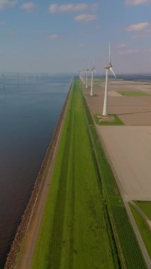 Yel değirmeni parkı bulutlarının ve mavi gökyüzünün drone hava görüntüsü, yel değirmeni türbinleri okyanusta yeşil enerji üretir. Hollanda Avrupa 'sında enerji geçişi