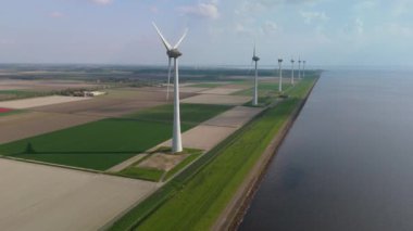 Kıyıdaki yel değirmeni bulutları ve mavi gökyüzü, yel değirmeni türbinleri okyanusta yeşil enerji üretir. Hollanda Avrupa 'da enerji geçişi, yel değirmeni türbinleri Ijsselmeer Gölü