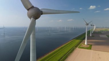 Kıyıdan uzak bir yel değirmeni parkı bulutuna ve mavi gökyüzüne yaklaşan yel değirmeni türbinleri okyanusta yeşil enerji üretir. Hollanda Avrupa 'sında enerji geçişi