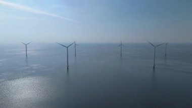 Kıyıda yel değirmeni parkı, yel değirmeni türbinleri okyanusta yeşil enerji üretir. Hollanda Avrupa 'sında enerji geçişi