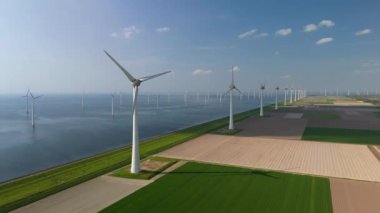  Yel değirmeni parkı, yeşil tarım arazisi, bulutlar ve mavi gökyüzü. Yel değirmeni türbinleri okyanusta yeşil enerji üretiyor. Hollanda Avrupa 'sında enerji geçişi