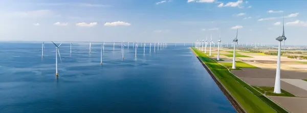 Suuri Vesistö Alankomaissa Flevolandia Ympäröivät Lukuisat Tuulimyllyt Niiden Terät Pyörivät tekijänoikeusvapaita kuvapankkikuvia
