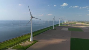 Kıyıdaki yel değirmeni bulutları ve mavi gökyüzü, yel değirmeni türbinleri okyanusta yeşil enerji üretir. Hollanda 'da enerji geçişi güneşli bir günde Avrupa' da