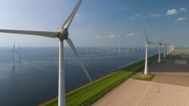 Kıyıdaki yel değirmeni bulutları ve mavi gökyüzü, yel değirmeni türbinleri okyanusta yeşil enerji üretir. Hollanda Avrupa 'sında enerji geçişi, Ijsselmeer Gölü kıyısındaki Hollandalı bir hendekte yel değirmenleri