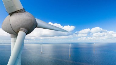 A mesmerizing aerial view of a wind farm in the ocean, with rows of windmill turbines gracefully spinning in the spring breeze, harnessing the power of the wind, green energy in the Netherlands clipart