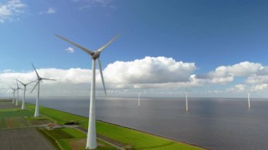 Baharda Hollanda 'daki yel değirmeni parkı, Avrupa' da yeşil enerji üreten yel değirmeni türbinlerinin insansız hava aracı görüntüsü, enerji geçişi