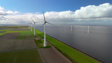 Baharda Hollanda 'daki yel değirmeni parkı, Flevoland Noordoostpolder' de elektrik üreten yel değirmeni türbinlerinin insansız hava görüntüsü.