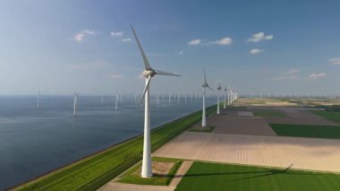 Bulutları ve mavi gökyüzü olan yel değirmeni parkı, yel değirmeni türbinleri okyanusta yeşil enerji üretir. Hollanda 'da enerji geçişi, sıfır atık karbon nötr