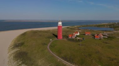 Yazın Wadden Adası 'nda kum tepeleri olan Hollanda Hollanda' nın batımında Texel deniz feneri. Güneşli bir günde mavi gökyüzü ile kumsalda drone hava manzarası