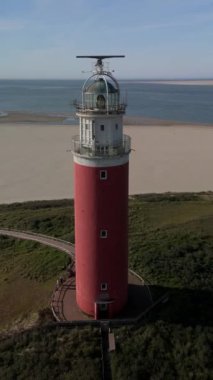 Teksas deniz feneri yaz günü Hollanda Hollanda 'da Wadden Adası' nda kum tepeleri olan bir ada. Gün batımında okyanusta gün batımında yukarıdan drone hava görüntüsü.