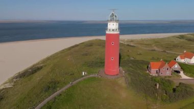 Teksas deniz feneri gün batımında Hollanda Hollanda adasında yazın Wadden Adası 'nda kumullar altında mavi gökyüzü ile güzel bir yaz günü