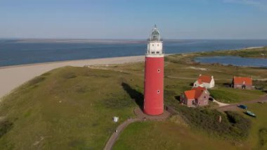 Teksas deniz feneri yaz günü Hollanda Hollanda 'da Wadden Adası' nda kum tepeleri olan bir ada. Gün batımında okyanusta gün batımında yukarıdan drone hava görüntüsü.