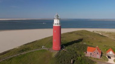 Yaz aylarında Hollanda Hollanda 'nın batımında Teksaslı deniz feneri. Teksas 'ın kumullarında mavi gökyüzü olan ikonik kırmızı deniz feneri