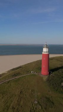 Teksas deniz feneri yaz günü Hollanda Hollanda 'da Wadden Adası' nda kum tepeleri olan bir ada. Gün batımında okyanusta gün batımında yukarıdan drone hava görüntüsü.