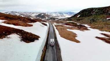 Norveç 'te Campervan veya karavan karavanı, Lyse yolunda karla kaplı karavan veya karavan karavanı, İlkbaharda karla kaplı Krejag Norveç Lysebotn yolu