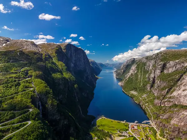 Norveç 'teki görkemli fiyorttan kıvrılarak geçen sarmal bir yolun nefes kesici hava manzarası, yüksek uçurumlar ve yemyeşil bitki örtüsü. Lysefjord, Norveç