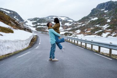 Karlı bir yolda bir çift adam ve kadın, Lyse yolu karla kaplı Krejag Norveç Lysebotn yolu, ilkbaharda karla kaplı bir yol