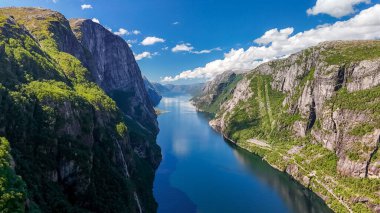 Norveç fiyordunun nefes kesen manzarası, yükselen uçurumlar, yemyeşil alanlar ve fiyordun kristal berrak suları. Kjerag, Lysebotn, Lysefjorden, Norveç