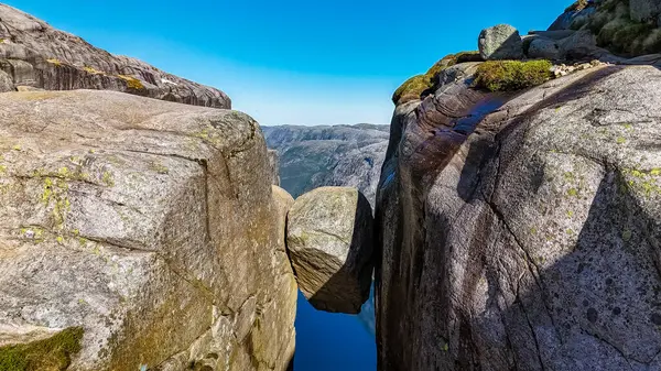 stock image A close-up view of a large, balanced rock formation in Norway. The rock is wedged precariously between two cliffs, creating a breathtaking natural wonder. Kjeragbolten, Norway