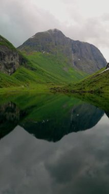 Norweigan fiyortları Stavbergvatnet Urke, bir vadinin kalbinde, yüksek dağlarla çevrili bir göl, çevresini saran yemyeşil çimenler ve bitkilerle huzurlu ve pitoresk doğal bir manzara yaratır.