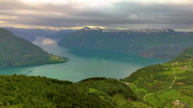 Yüksek dağlar ve yeşil ağaçlarla çevrili, Molden yürüyüşünden LustraFjord, Sogn Norveç 'e kadar uzanan etkileyici bir göl manzarası.