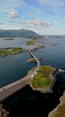 Atlantik Okyanusu Yolu Norveç, sakin su üzerindeki görkemli bir köprünün havadan görünüşü, sakin manzaraya karşı çarpıcı mimari güzelliğini vurguluyor.