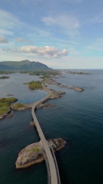 Etkileyici bir hava manzarası, titreyen bir su kütlesinin üzerinde bir köprü sergiliyor, seyirciler için huzurlu ve güzel bir manzara yaratıyor, Atlantik Okyanusu Yolu Norveç.