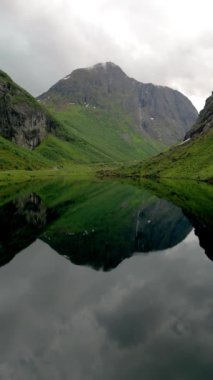 Norweigan fiyortları Stavbergvatnet Urke, bir vadinin kalbinde, yüksek dağlarla çevrili bir göl, çevresini saran yemyeşil çimenler ve bitkilerle huzurlu ve pitoresk doğal bir manzara yaratır.