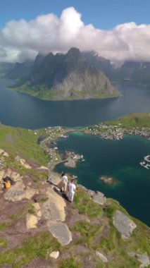 Reinebringen Lofoten Adaları 'nın tepesinde, Reinebringen' in tepesinde duran bir çift kadın ve erkek. Reine bakış açısına giden turistik yol