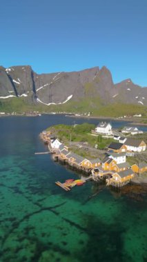 Norveç 'in Lofoten Adaları, Norveç' in Sakrisoy, Norveç, İskandinavya 'nın tarihi köyünde geleneksel sarı balıkçı Rorbuer kulübeleriyle Lofoten Adaları manzarası