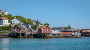 Reine, Lofoten, Norveç manzaralı, berrak mavi gökyüzü ve arka planda sakin suları olan sular..